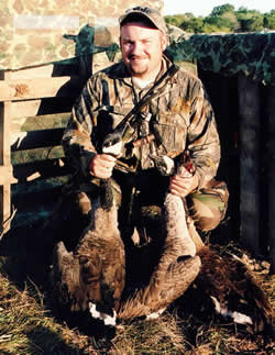 Hunter in blind with geese