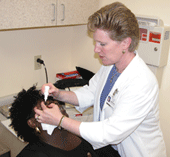 Eye Health Nurse applies eye drops to client
