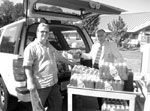 Joseph Brandspiegel (right), Chief Executive Officer, Menlo Park Veterans Memorial Home and Roger Vonah (left), driver, pose with some of the water collected for the hurricane Katrina relief effort. Photo by Christine McNulty.
